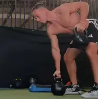 Fabián Avendaño entrenando intensamente con kettlebells en el gimnasio